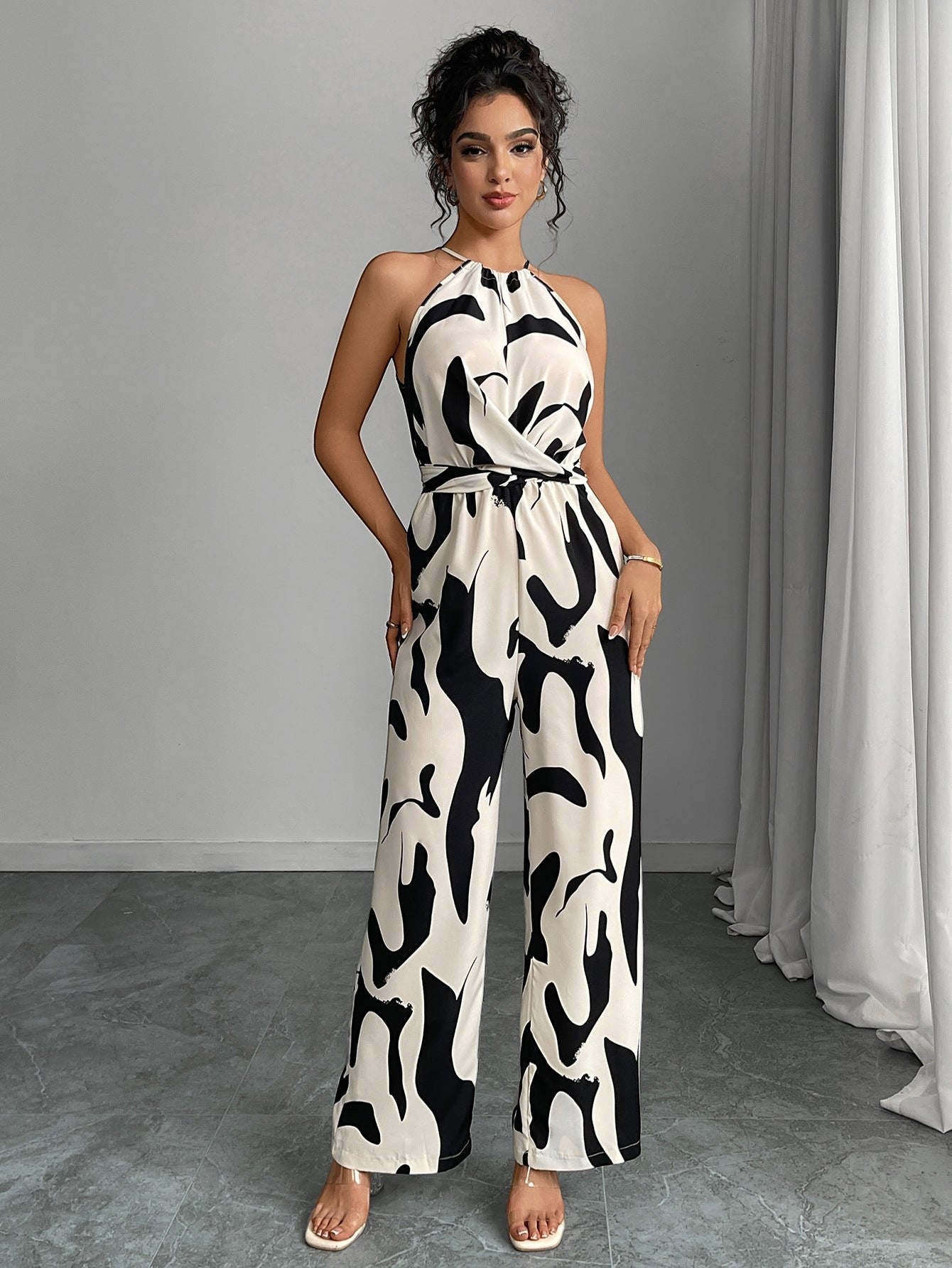 URHER Nia Utility Jumpsuit, a black and white abstract print halter neck jumpsuit with a tie waist and wide legs.