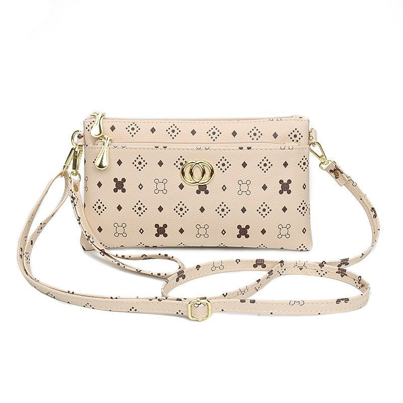 URHER Dion beige mini crossbody bag with vintage print and gold hardware. Adjustable strap.