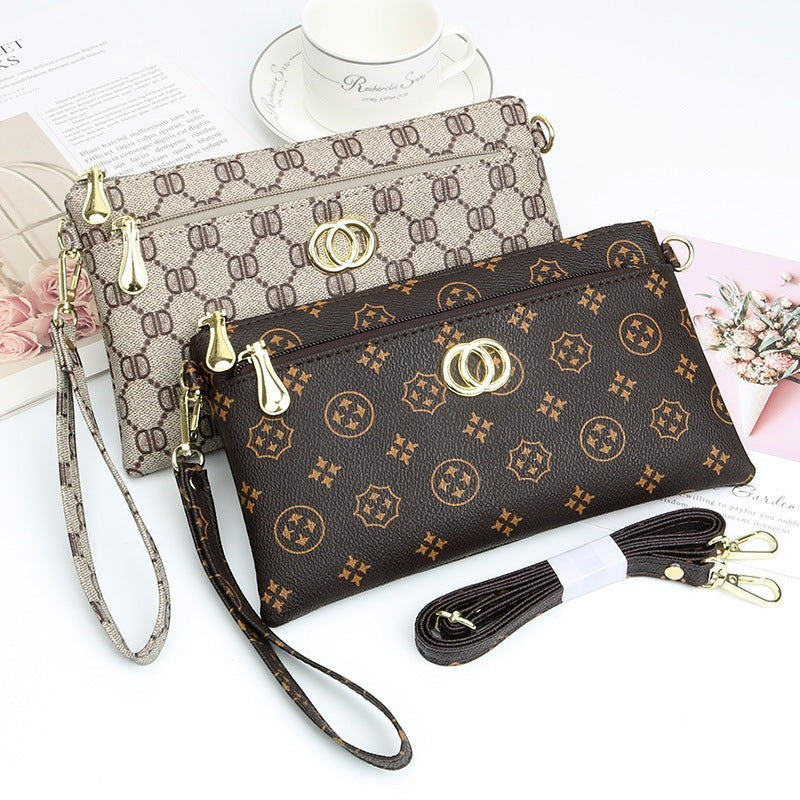URHER Dion vintage print mini crossbody bag in brown and beige with gold hardware and detachable straps.