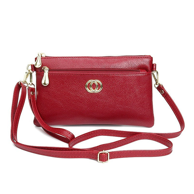 URHER Dion red leather crossbody bag with gold hardware and double ring logo.